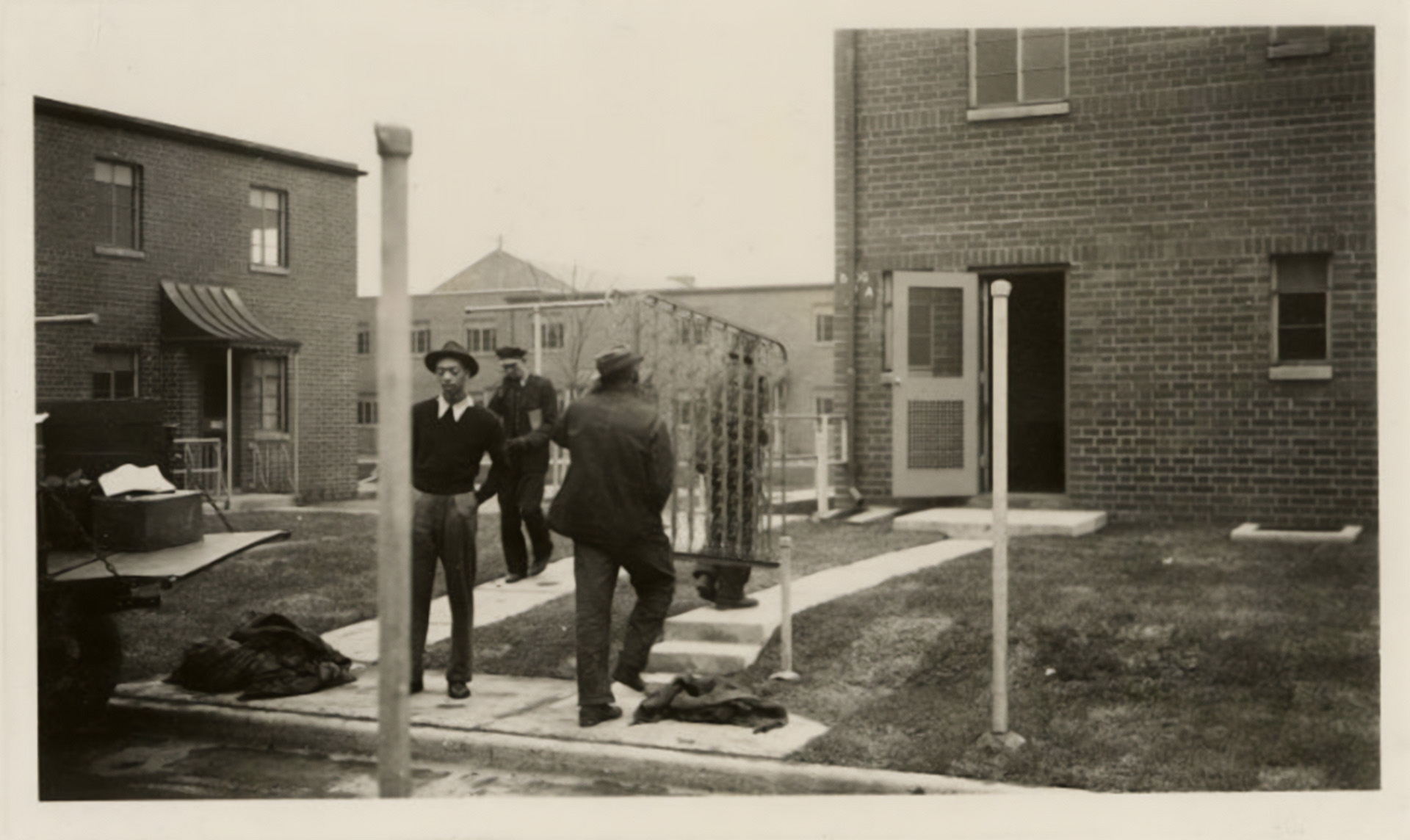 Dated May 13, 1940, this photograph shows two men carrying a metal fixture into one of the units at Poindexter Village in Columbus, Ohio.